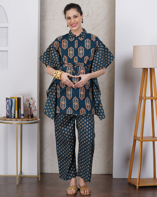 A pregnant woman showing maternity pose with heart hand on bump, wearing maternity co-ord set with kaftan style top and matching pant set.