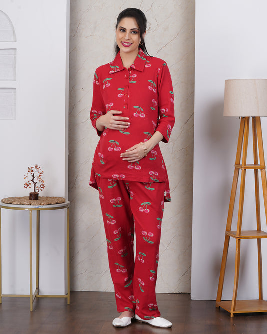 Pregnant Woman wearing a red maternity and nursing pajama set with cherry pattern, standing in a room .
