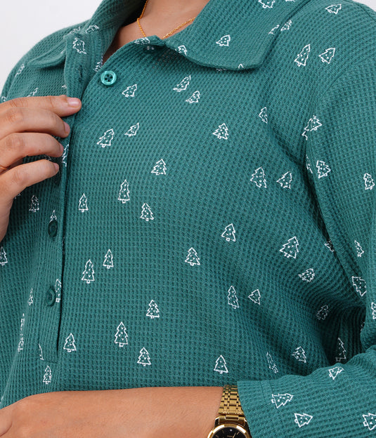 Green textured shirt with white christmas tree pattern worn by a person