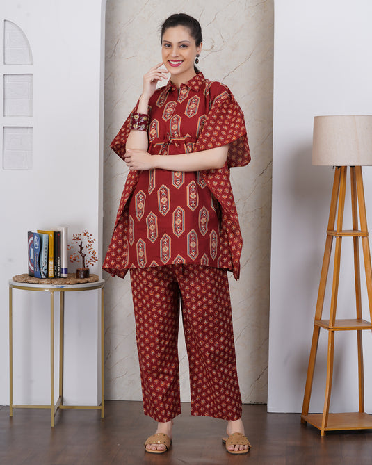 A woman wearing dark red kurta set with matching pant against a geometric motif print.