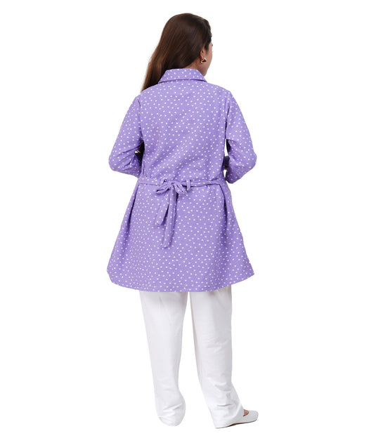 Woman wearing a purple polka dot dress with a belt on a white background