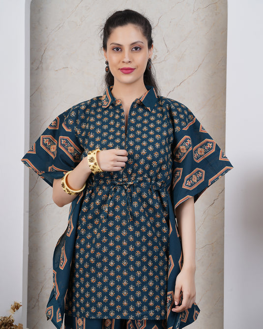 Woman wearing a blue top with zips in floral motif print.