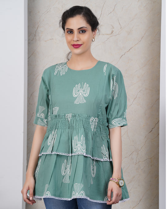 Woman wearing a green dress with white patterns against a neutral background