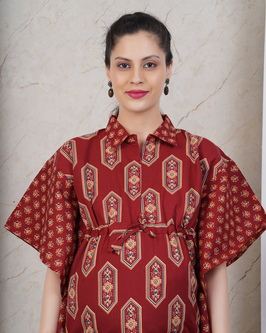 A woman wearing kaftan style top in dark earthy red shade.