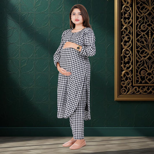 Pregnant Woman wearing a black and white checkered maternity outfit standing against a dark green wall with decorative elements.