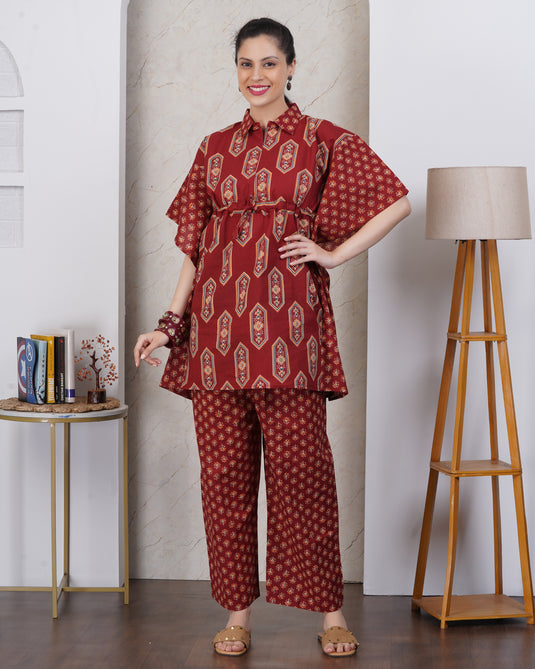 A woman wearing dark red matching top and pant set with floral motif.